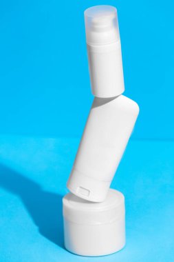 Arka planda reklam metni için boş alanı olan boş beyaz cilt kozmetik ürünleri seti. Yüzen boş nemlendirici ve hijyen şişesi.