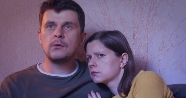 Par tittar skrämmande film hemma och äter popcorn — Stockvideo