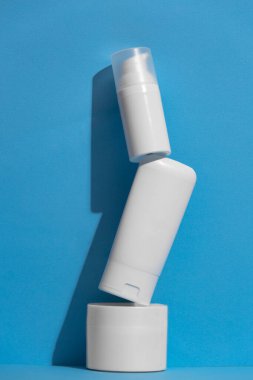 Arka planda reklam metni için boş alanı olan boş beyaz cilt kozmetik ürünleri seti. Yüzen boş nemlendirici ve hijyen şişesi.