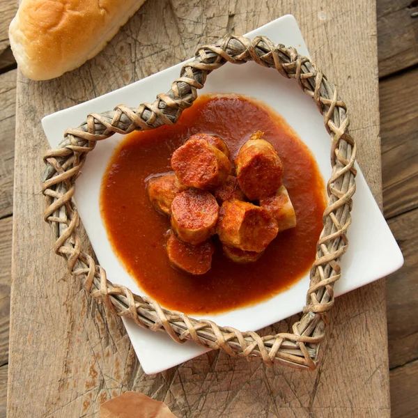 Beyaz tabakta köri soslu sosis yemek için servis edildi. Köri aşıkları yemek aperatifi. Geleneksel Hint mutfağı.