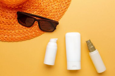 Plajdaki güneş ışığından korunmak için güneş kremi ve sprey. Yaz tatili kozmetik konsepti.