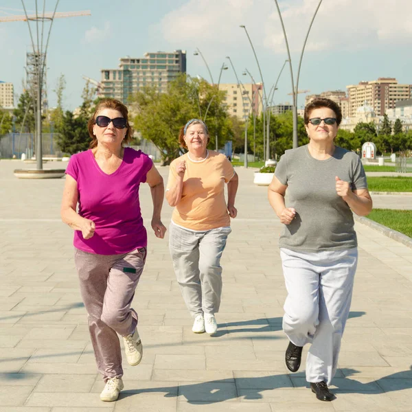 Tres mujeres corriendo en el parque público, teniendo un estilo de vida saludable para la inmunidad. — Foto de Stock