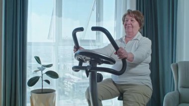 Evde bisiklet eğitmeni eğitimi alan yaşlı bir kadın emeklilikten sonra sağlıklı bir yaşam sürüyor. Yüksek kalite fotoğraf