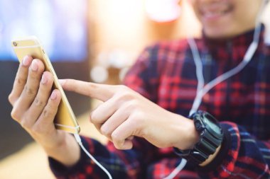 Genç adam arka plandaki istasyon platformunda gece telefon kullanarak hareket eden elektrik trenini bekliyor. Turist mesajları ve durak ve demiryolu taşımacılığının planı. Keyifli yolculuklar..