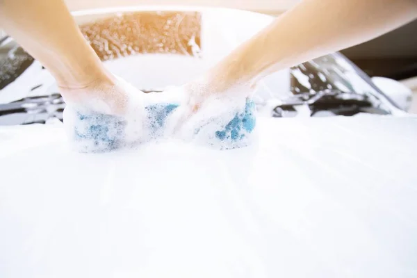 女性手用蓝色海绵清洁洗车侧镜 概念洗车 — 图库照片