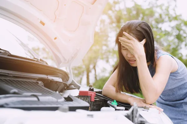 broken car on the road and smart phone, woman hand holding mobile smart phone,cellphone Contact ask for help car technician repairing the car in garage.