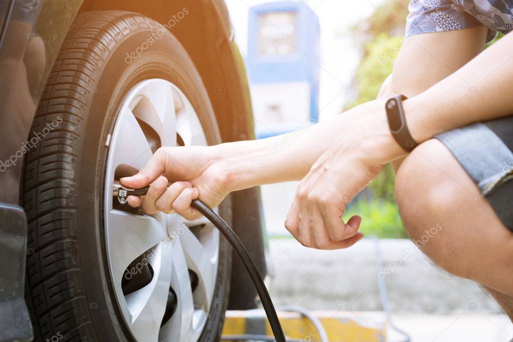 close up hand man car parking a check the tire fill up the air for safe driving on the go.