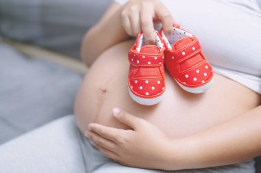 Beyaz iç çamaşırı Yeni anne Hamile kadın Kalp şeklinde el bebek ile aşk gösterisi. Bebek bekleyen genç kadın açık havada durun.