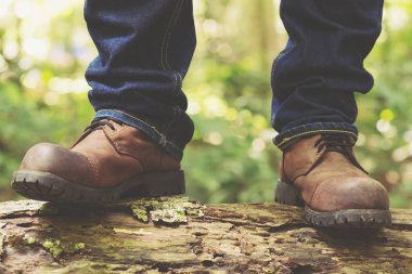 Yürüyüş ayakkabıları ile bir dağ veya ormanda eylem yürüyüş yolu. erkek yürüyüşçüler ayakkabı. dağ botları giyerek ve kereste üzerinde yürüyoruz orman yolu üzerinde yürüyoruz. Hedef Deneyimi. Moss.
