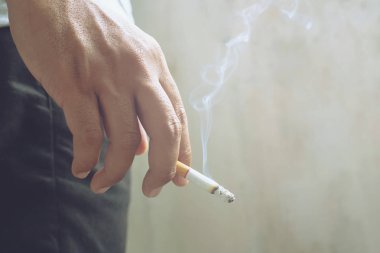 Elinde sigara içen adam. Sigara dumanı yayılması