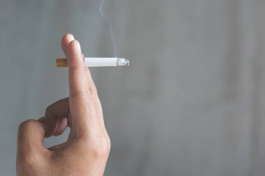Elinde sigara içen adam. Sigara dumanı yayılması.