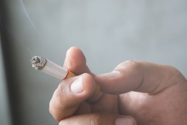 Elinde sigara içen adam. Sigara dumanı yayılması.