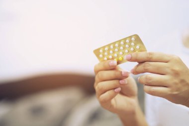Kadın elleri elinde doğum kontrol hapları açıyor. Yeme Kontraseptif Hap.