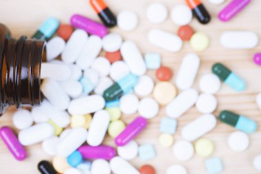 Hap şişesi dökülüyor. bir masa ahşap arka plan üzerinde yüzey tabletleri renkli hapları. üst görünüm. ilaç tıbbi sağlık kavramı