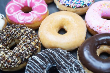 çikolata frosting ile çeşitli donutlar, serpin donuts Renkli çeşitli ve ahşap bir arka plan üzerinde tatlar Çeşitli. üst görünüm