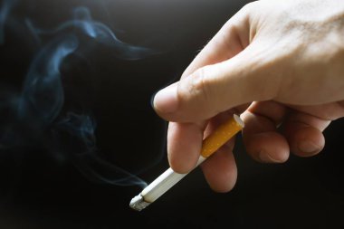 bir yumuşak odak arka plan siyah elinde sigara Sigara.