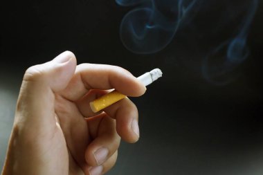 bir yumuşak odak arka plan siyah elinde sigara Sigara.