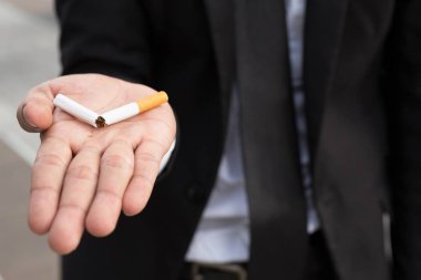 Sigarayı ve sağlıklı yaşam tarzını bıraktığı için sigara kavramını reddeden bir adam.ya da sigara yasağı kampanyası konsepti yok. siyah koyu arka plan.