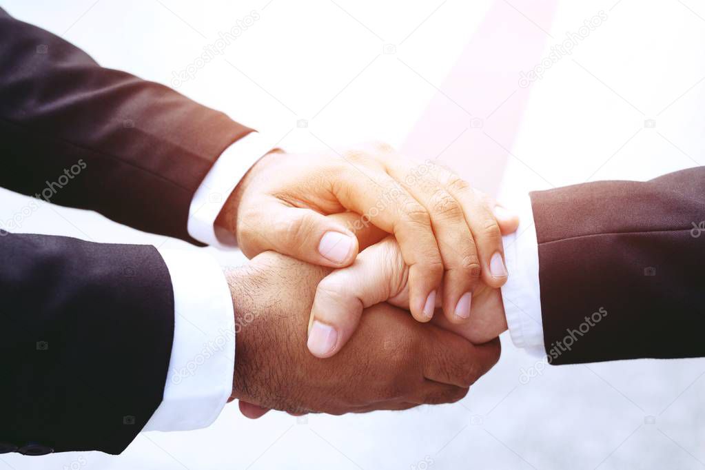 companionship hand clasping success trust, confident concept. or Closeup of a businessman hand between two colleagues on outdoor building.
