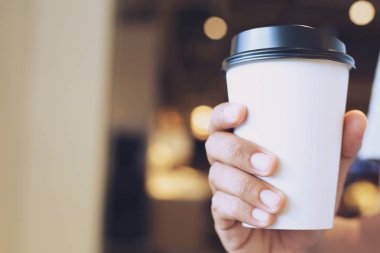 Genç adam el tutmak kağıt bardak almak uzağa kahve sıcak içecek kafe kahve dükkanı.