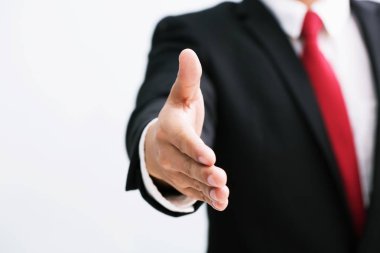 Takım elbise ve kırmızı kravat açık el iş adam bir anlaşma mühürlemek için hazır, bir el ortağı tutun el sallamak, kopya alanı. Beyaz arka plan.