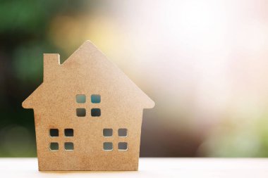 Bahçe arka planda ahşap masa üzerinde kahverengi geri dönüşümlü kağıt modeli ev. Çevre dostu ev.