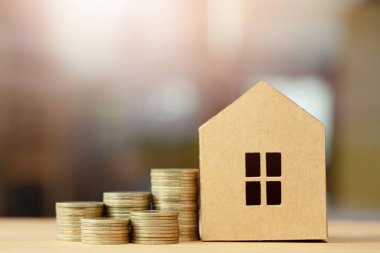 kahverengi geri dönüşümlü kağıt modeli ve para sikke ahşap masa arka plan üzerinde farklı pozisyonlarda birbirlerine yığılmış ev. ev kredisi finansal kavramı.