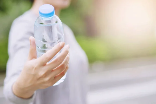 Młoda Kobieta Gospodarstwa Rękę Dać Świeżą Butelkę Wody Pitnej Tworzywa — Zdjęcie stockowe