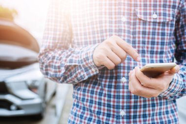 yakın bir cep telefonu akıllı telefon arama kullanarak genç iş adamı el bir araba tamircisi yardım isteyin çünkü araba yol kenarında kırık. boş ekran varsa.