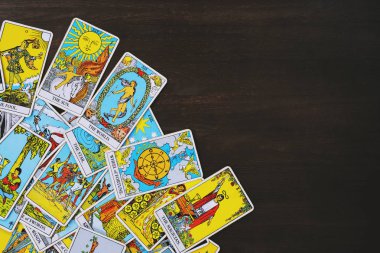 Tahta bir arka plandan esinlenilmiş, dağınık ve gelişigüzel düzenlenmiş bir Tarot kartlı çingene destesi. Falcı, sihirbaz, büyücü. Yıldız falı