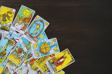 Tahta bir arka plandan esinlenilmiş, dağınık ve gelişigüzel düzenlenmiş bir Tarot kartlı çingene destesi. Falcı, sihirbaz, büyücü. Yıldız falı