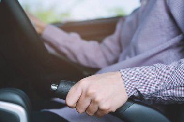 Park ederken güvenlik için araçta el freni kolu çeken kişinin yakın çekim.