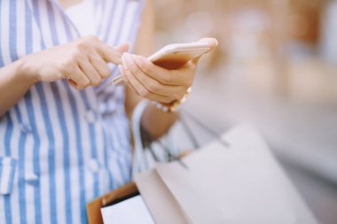 Satın alma sonra kopya alanı ile sokak boyunca yürüyüş, yaz satışı ve insan kavramı zevk hediyeler aldıktan sonra moda butik el birçok alışveriş çantası tutarak tüketim genç kadın yakın