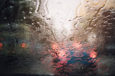Akşam ları camın ön camına Yağmur Damlaları. şiddetli yağmurda sokak. Bokeh Kuyruk ışığı. yumuşak Odak. Lütfen dikkatli sür, kaygan yoldan. yumuşak odak.