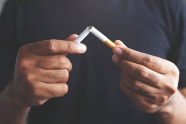Sigarayı ve sağlıklı yaşam tarzını bıraktığı için sigara kavramını reddeden bir adam.ya da sigara yasağı kampanyası konsepti yok. yumuşak odak.