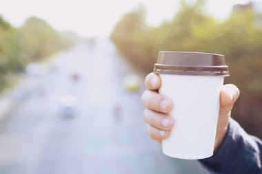iş adamı el doğal sabah güneş ışığında kahve içme götürmek kağıt fincan tutarak. metin veya logonuz için yer.