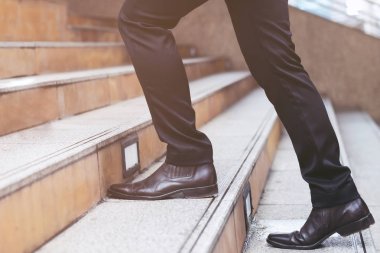 modern şehirde merdivenlerden yukarı yürüyen yakın bacaklar çalışan modern işadamı. acele ofiste çalışmak için yoğun saat. İşin ilk sabahında. Merdiven. yumuşak odak.