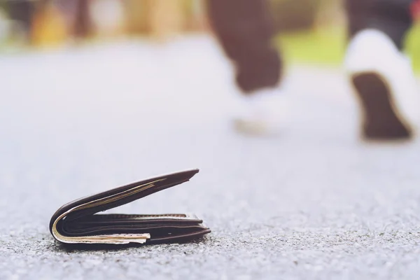 実業家は路上でお金で革の財布をなくした 出張中に歩道に横たわる財布のクローズアップ — ストック写真