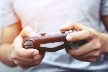 Genç adam eller denetleyicisi oyun joystick video oyun konsolu denetleyicikonsolda oynuyor.