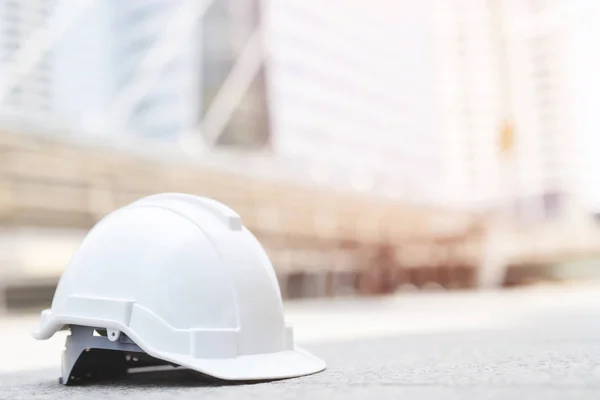 beyaz sert güvenlik güneş ışığı ile şehir beton zemin üzerinde şantiye binasında projede kask şapka giymek. mühendis veya işçi olarak işçi için kask. önce konsept güvenliği.
