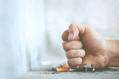 Adam el yumruk sigara reddederek mola yok. sigarayı bırakmak ve sağlıklı yaşam tarzı.ya da sigara içmeme kampanyası. Beton zemin üzerinde sigara izmariti, çıplak çimento.