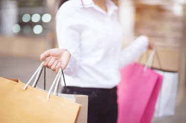 Satın alma sonra kopya alanı ile sokak boyunca yürüyüş, yaz satışı ve insan kavramı zevk hediyeler aldıktan sonra moda butik el birçok alışveriş çantası tutarak tüketim genç kadın yakın