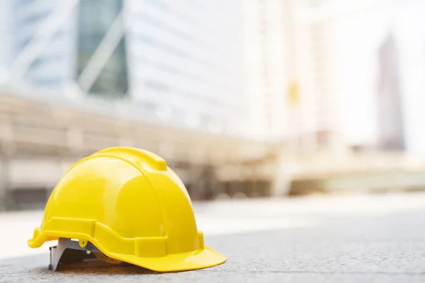 sarı sert güvenlik güneş ışığı ile şehir beton zemin üzerinde şantiye binasında projede kask şapka giymek. mühendis veya işçi olarak işçi için kask. önce konsept güvenliği.