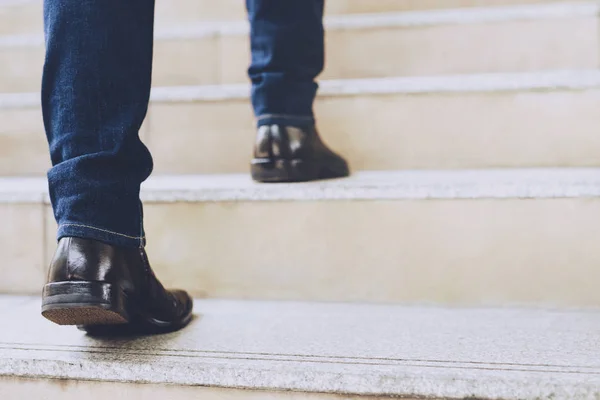 Close up legs shoes of young business man One person walking stepping going up the stairs in modern city, go up, success, grow up. with filter Tones retro vintage warm effect. stairway
