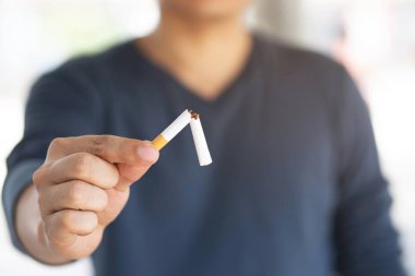 Sigarayı ve sağlıklı yaşam tarzını bıraktığı için sigara kavramını reddeden bir adam.ya da sigara yasağı kampanyası konsepti yok. siyah koyu arka plan.