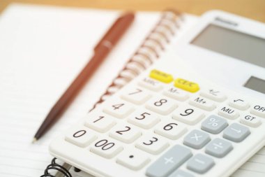 Hesap makinesi kullanarak işadamı elini kapatın ve not defterine yazarak not lar hesaplatArak ev ofisinde finans yapıyor. Tasarruf finans kavramı. not defteri