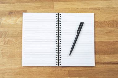 Yüz çizim not defterinin ve kopya alanı olan ahşap arka plan üzerine bir kalemin üstünden görüntüleyin. üst görünüm boş not defteri ve metin.
