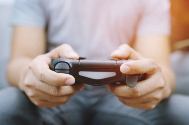 Genç adam eller denetleyicisi oyun joystick video oyun konsolu denetleyicikonsolda oynuyor.