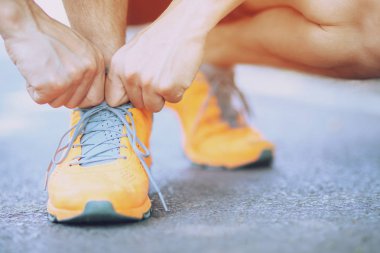 yalınayak koşu ayakkabıları yakın. erkek atlet bağlama bağcıklar bağcıkları yol beton zeminüzerinde koşu için. Koşucu bağları eğitime hazırlanıyor. Spor yaşam tarzı.