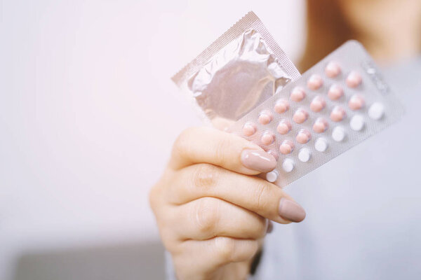Woman hands opening birth control pills in hand. Eating Contraceptive Pill.